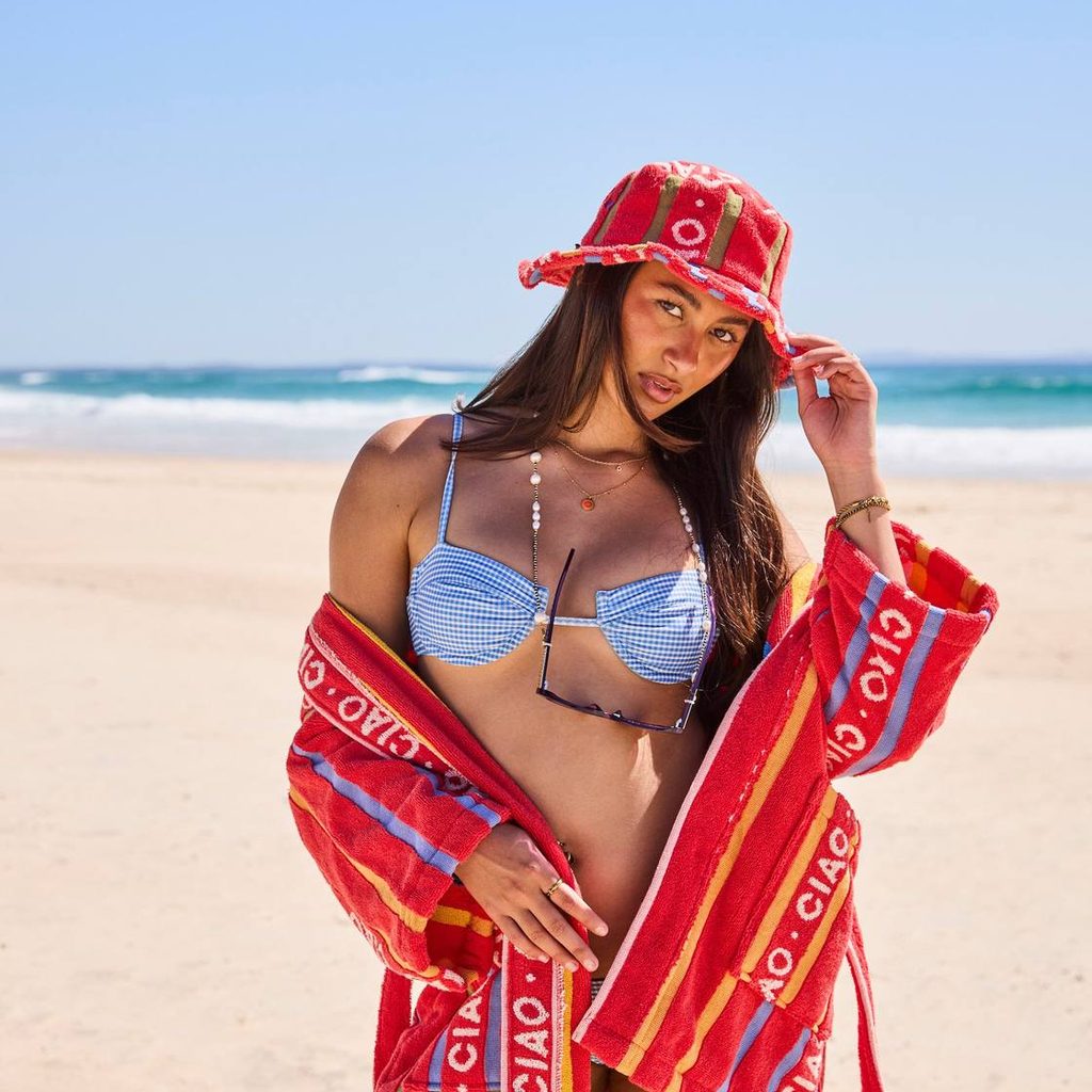 Woman in the Ciao Stripe hat and matching robe on the beach