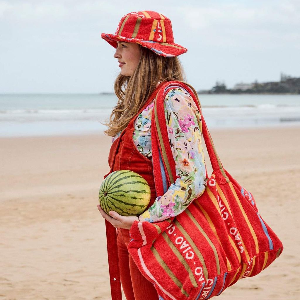 Woman on the beach carrying the Ciao Stripe beach bag and a watermelon