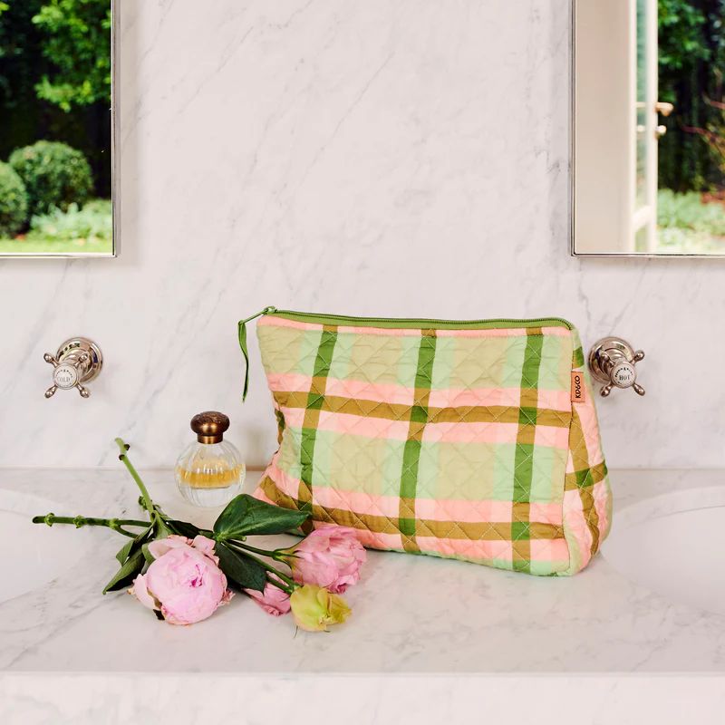 The image likely shows a stylish toiletry purse from Kip & Co in a pistachio tartan pattern, available at Cove Beach Essentials.