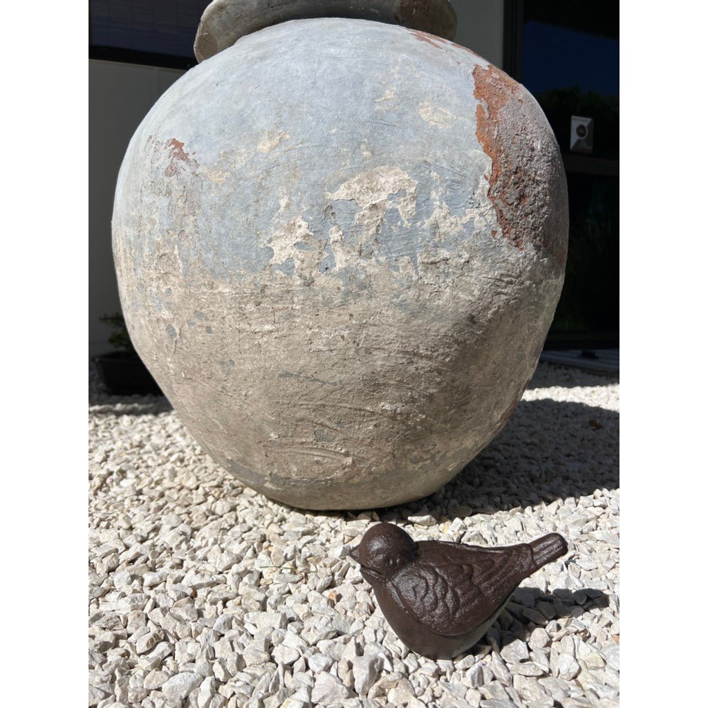 Cast iron bird ornament on garden gravel