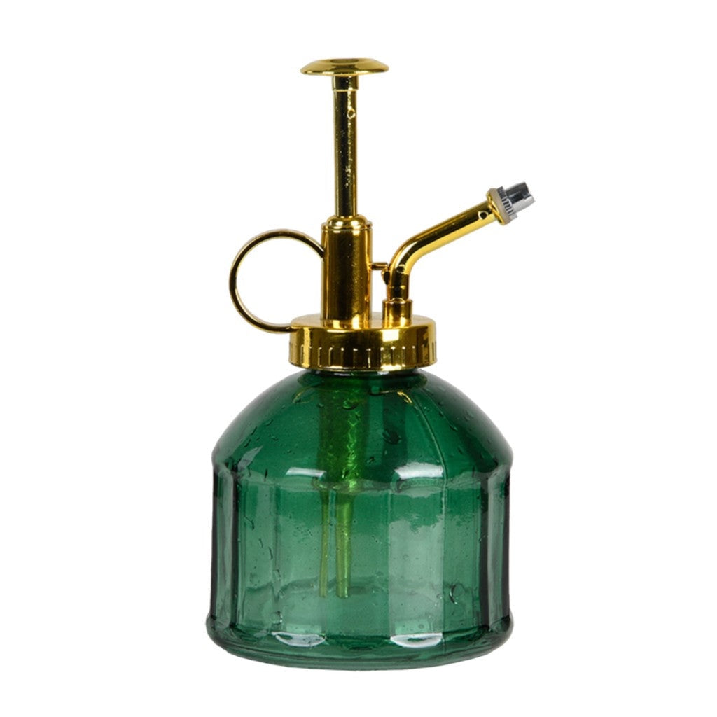 Green glass plant mister with brass pump on white
