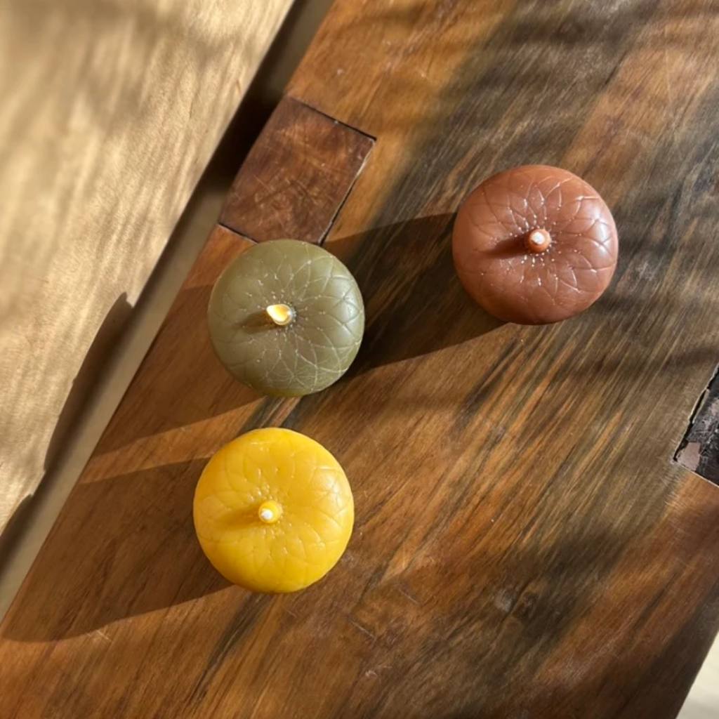 A close-up image of a cluster of acorns, showcasing their smooth, brown shells and textured caps, resting on a wooden surface. The acorns are arranged in a natural, organic manner, highlighting their earthy tones and intricate details.
