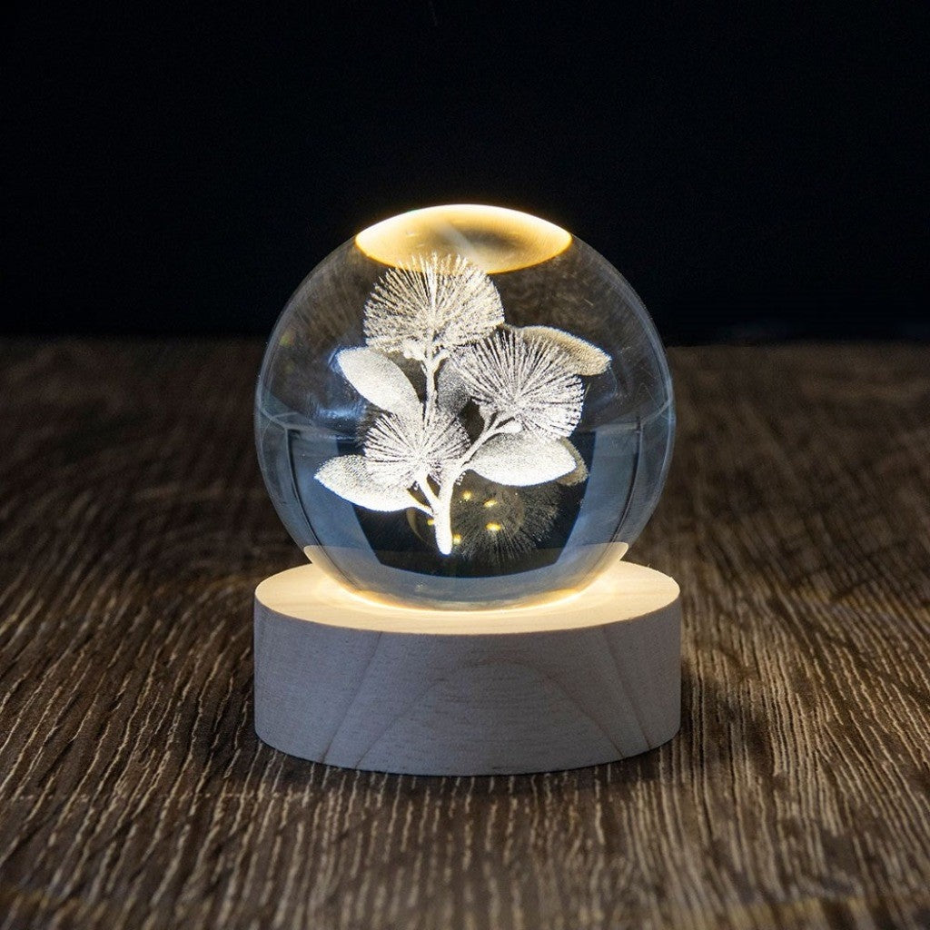 Pohutukawa LED Globe lit up on its wooden base