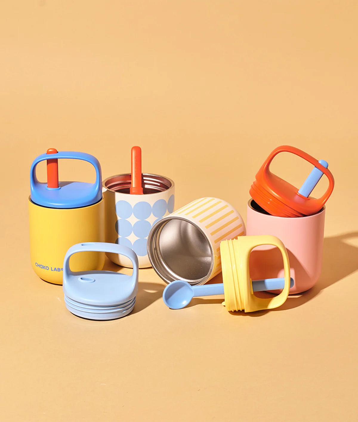 Pink water bottle with orange handle and blue cap on a light gray background