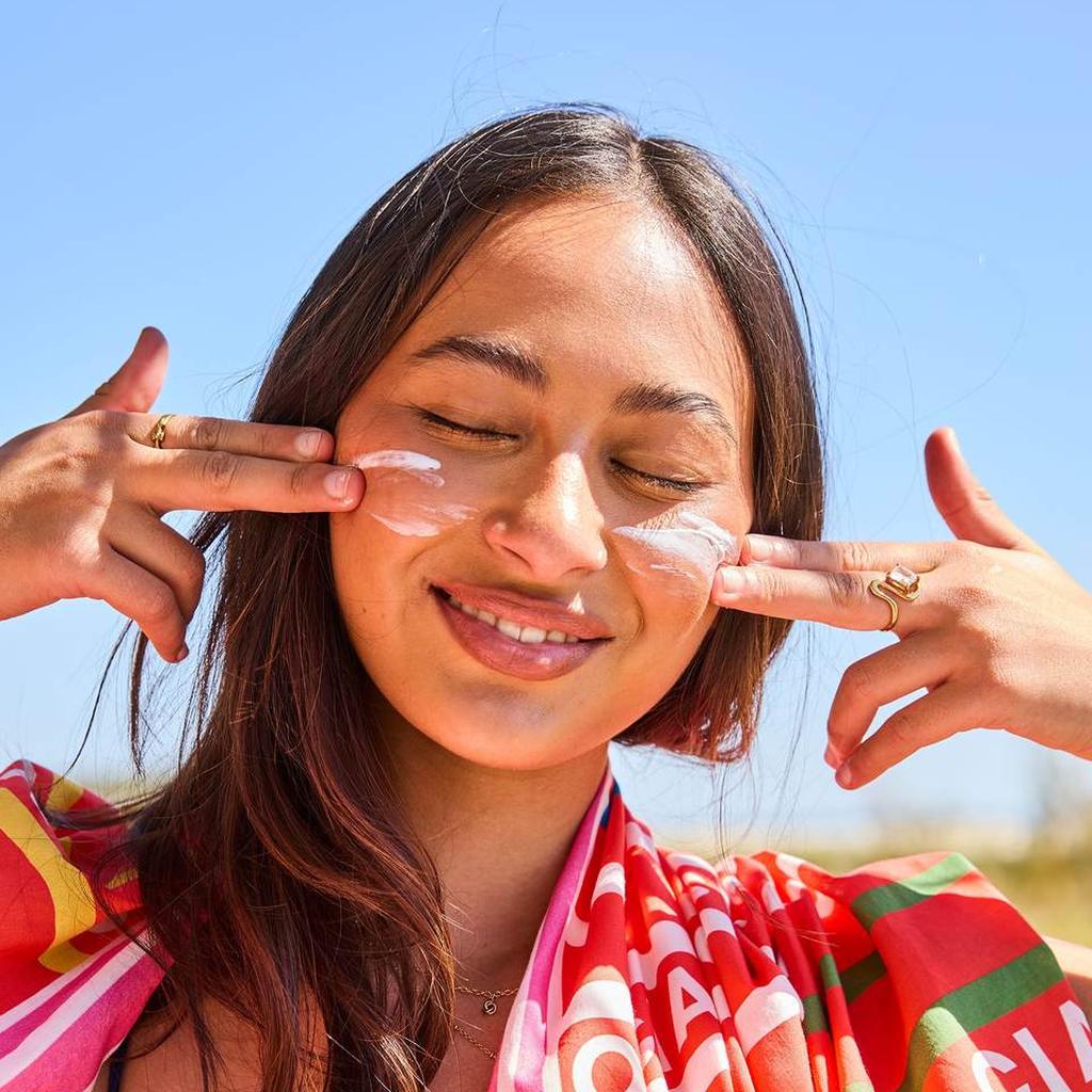 Woman with sunscreen on her face and the Ciao Stripe sarong over her shoulders