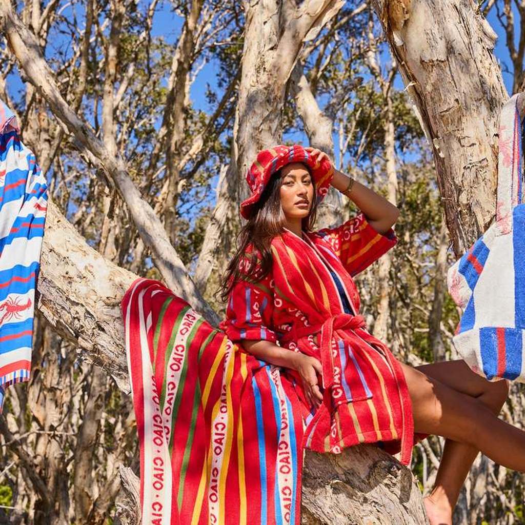 Woman sitting in a tree in the Ciao Stripe hat and robe