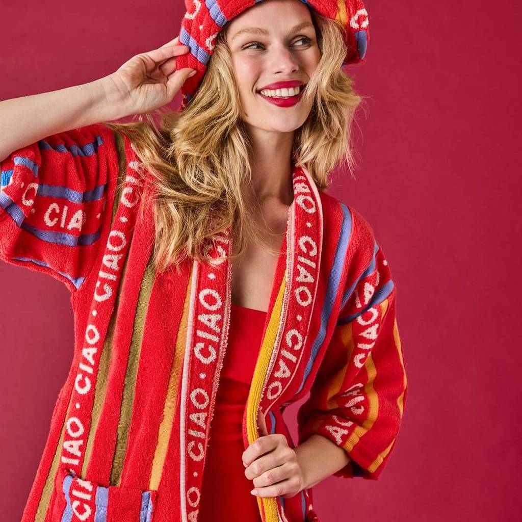 Woman in the Ciao Stripe hat and robe on a red background