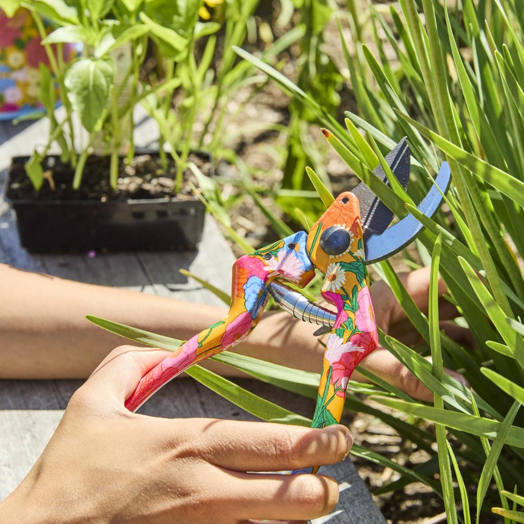 The image shows a set of yellow garden tools and gloves. The tools include a trowel, a hand fork, and a pair of pruning shears, all featuring bright yellow handles. The gloves are also yellow, matching the tools, and appear to be made of a durable material suitable for gardening tasks. The set is neatly arranged, likely on a flat surface, showcasing the cohesive design and color theme.