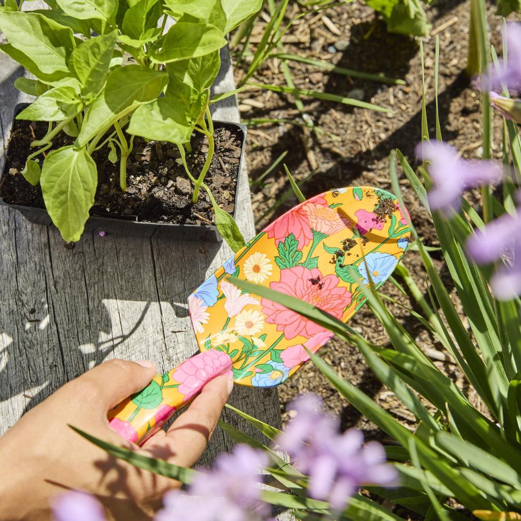 The image shows a set of yellow garden tools and gloves. The tools include a trowel, a hand rake, and a pruner, all featuring bright yellow handles. The gloves are also yellow, matching the tools, and appear to be made of a durable material suitable for gardening. The set is neatly arranged, likely on a flat surface, showcasing the cohesive design and color theme.