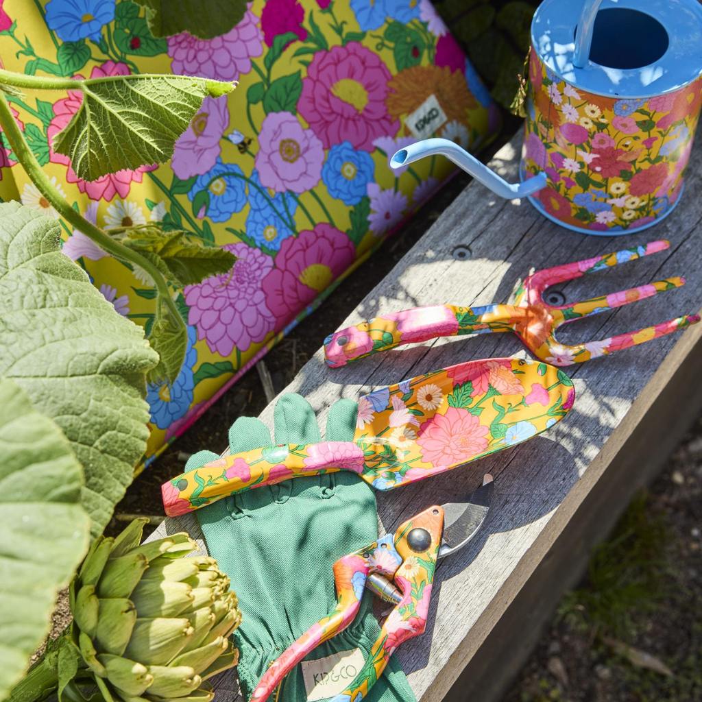 The image shows a set of yellow garden tools and gloves. The tools include a trowel, a hand fork, and a pair of pruning shears, all featuring bright yellow handles. The gloves are also yellow, matching the tools, and appear to be made of a durable material suitable for gardening. The set is neatly arranged, likely on a flat surface, showcasing the cohesive design and color theme.