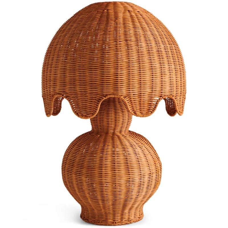 The image shows a beautifully designed Genie Rattan Lamp by Kip & Co. The lamp features a handwoven rattan shade that exudes a warm, cozy glow, perfect for brightening up any space. Its natural texture and intricate weaving highlight the craftsmanship and ethical production behind the piece, making it both a stylish and responsible choice for home decor.