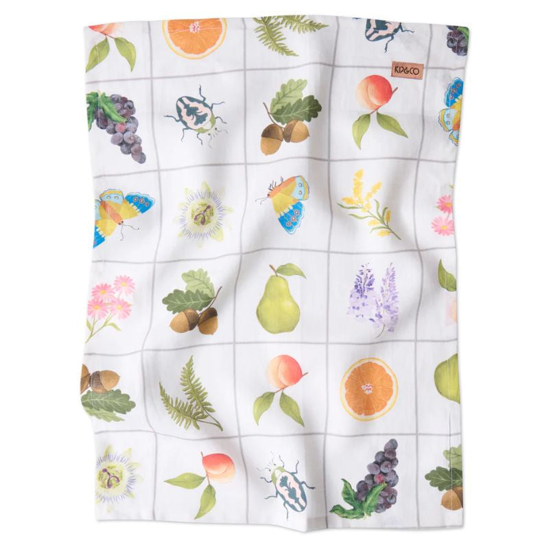 The image shows a beautifully designed Kip & Co Prairie Linen Tea Towel available at Cove. The towel is made from 100% French flax and is eco-friendly, featuring a vibrant and colorful pattern that adds a touch of elegance to any kitchen setting.