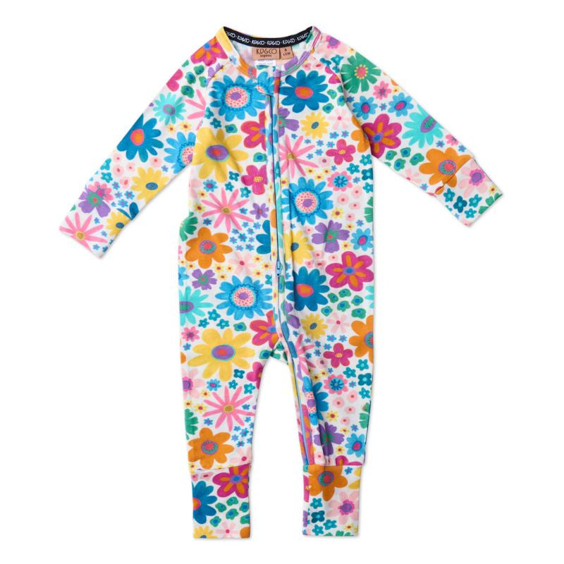 The image likely showcases Kip & Co's Rainbow Flowers Romper, a vibrant and colorful piece of clothing designed for comfort and style. The romper features a playful floral pattern with a rainbow of colors, perfect for adding a pop of color to any wardrobe. It is available at Cove Beach Essentials and is noted for being eco-friendly, aligning with sustainable fashion practices.