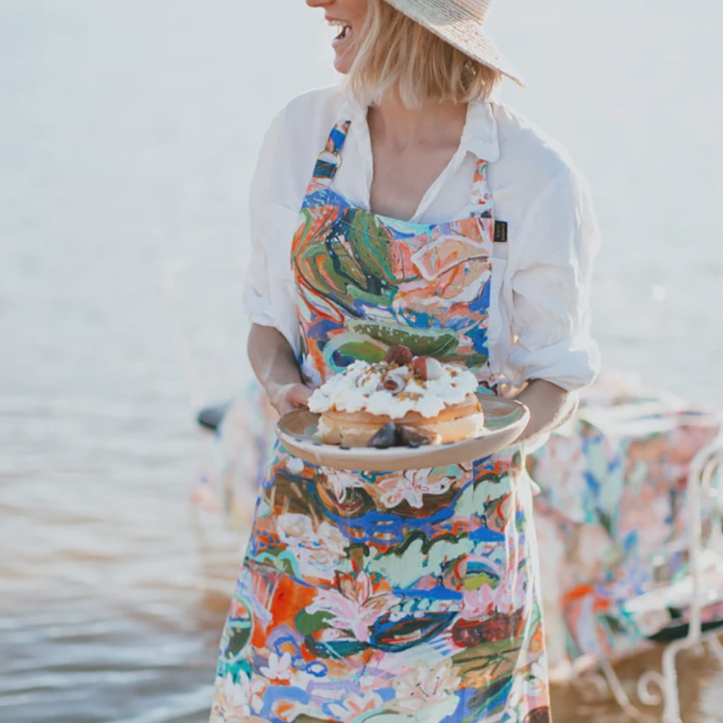 Upgrade your kitchen with the stylish Kip &amp; Co x Kezz Brett Waterlily Apron available at Cove. This apron features a vibrant waterlily design, perfect for adding a splash of color and creativity to your cooking space.