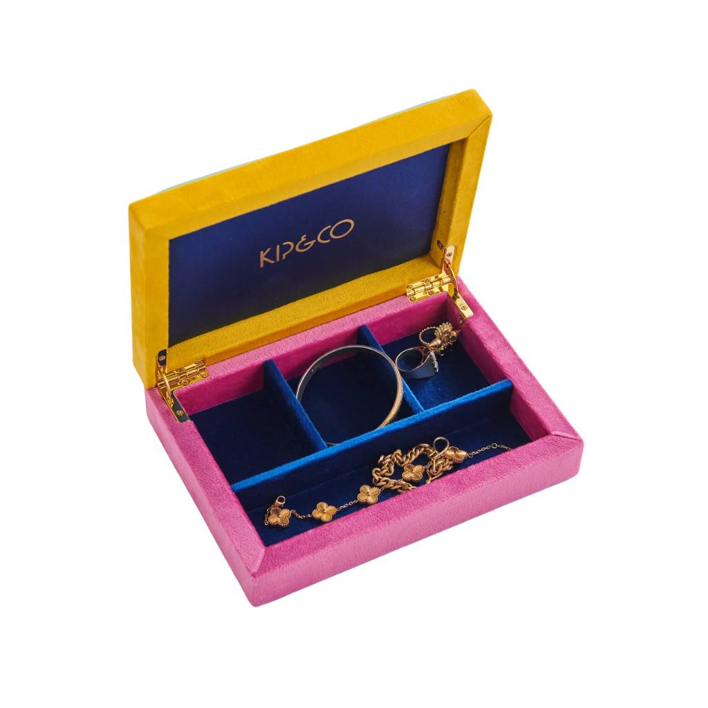 The image likely showcases Kip & Co's Jewels Velvet Box, a stylish and vibrant product available at Cove. The box is made from luxurious velvet material and features a colorful, eye-catching design. Kip & Co is known for its commitment to ethical production practices, ensuring that their products are both fashionable and responsibly made.