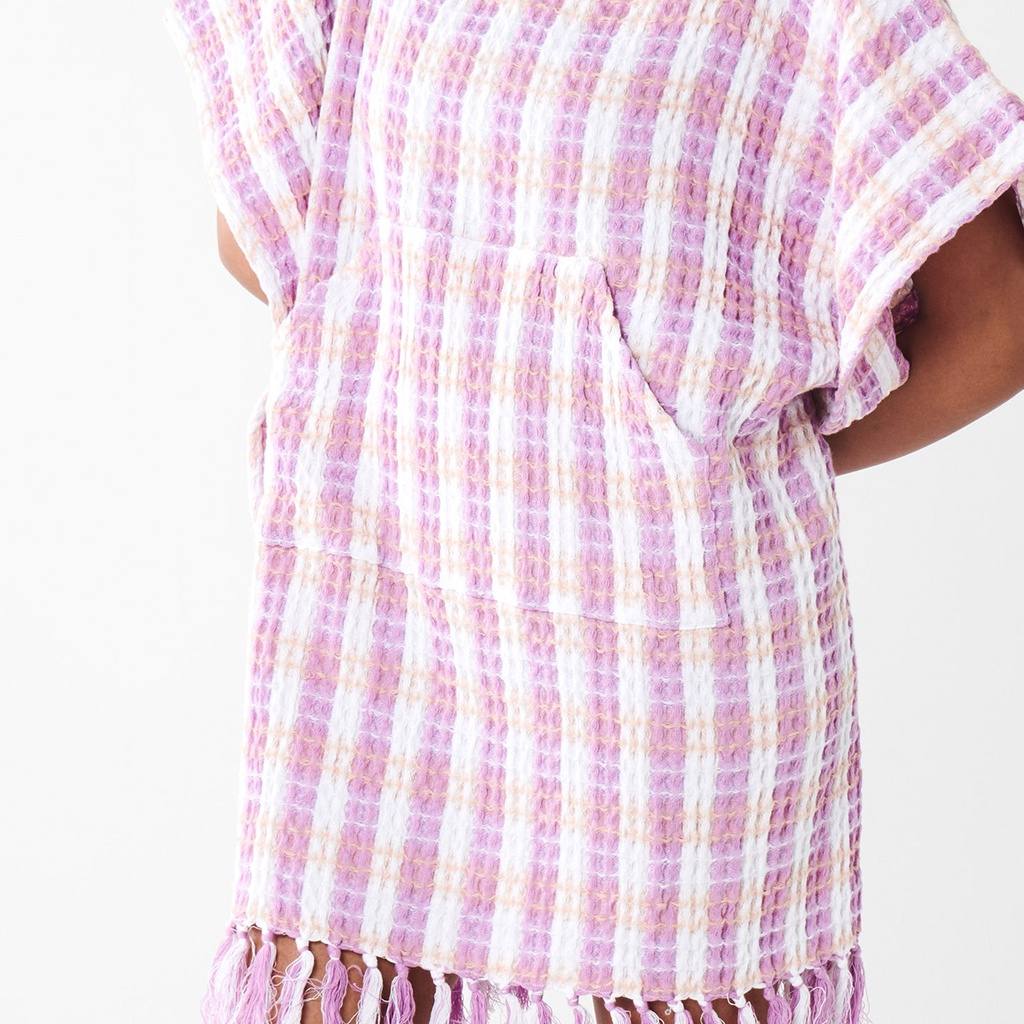 Close-up of a person wearing a pink and white checkered dress with a plain background