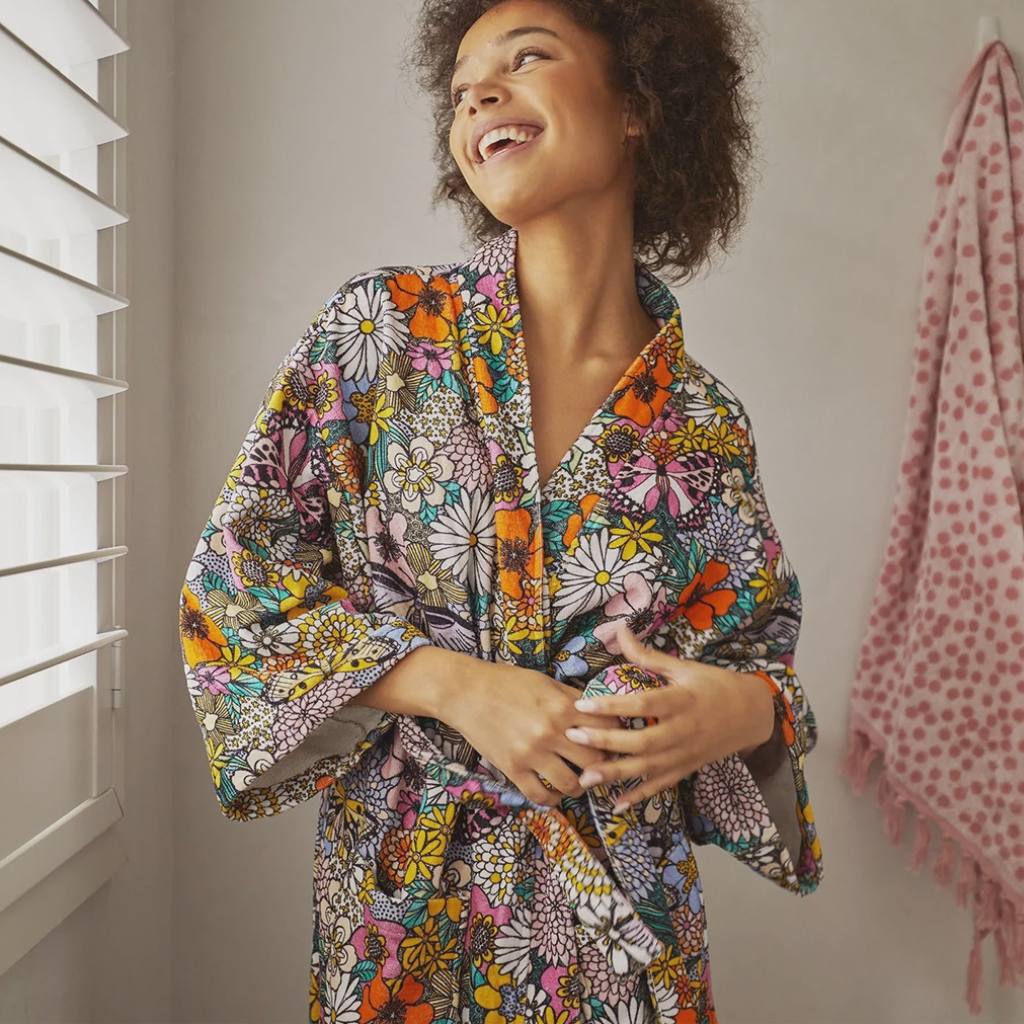 The image likely shows a cozy and stylish Kip & Co Bliss Floral Terry Bath Robe available at Cove. The robe is made from 100% cotton, featuring a vibrant floral design that combines comfort with a touch of elegance.
