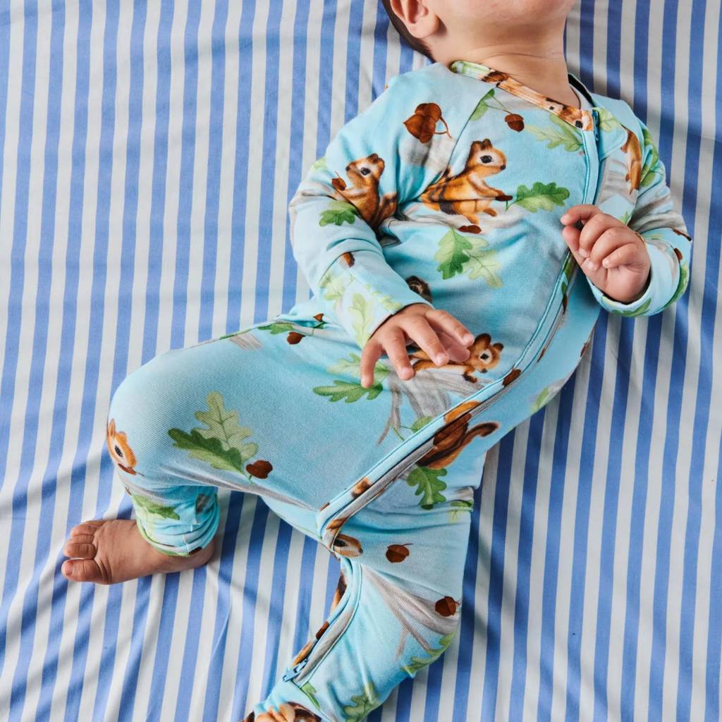 The image likely showcases Kip & Co's Squirrel Scurry Romper, highlighting its eco-friendly and cozy design. The romper may feature playful squirrel patterns and is available at Cove, emphasizing its sustainable and comfortable qualities.