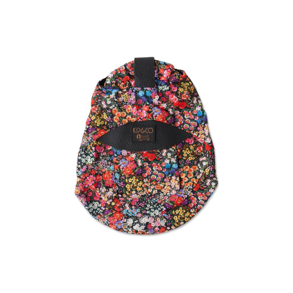 The image shows a stylish dog jacket from Kip & Co, designed for large dogs. The jacket features a vibrant floral pattern on a black background, adding a touch of chic elegance to your pup's wardrobe.
