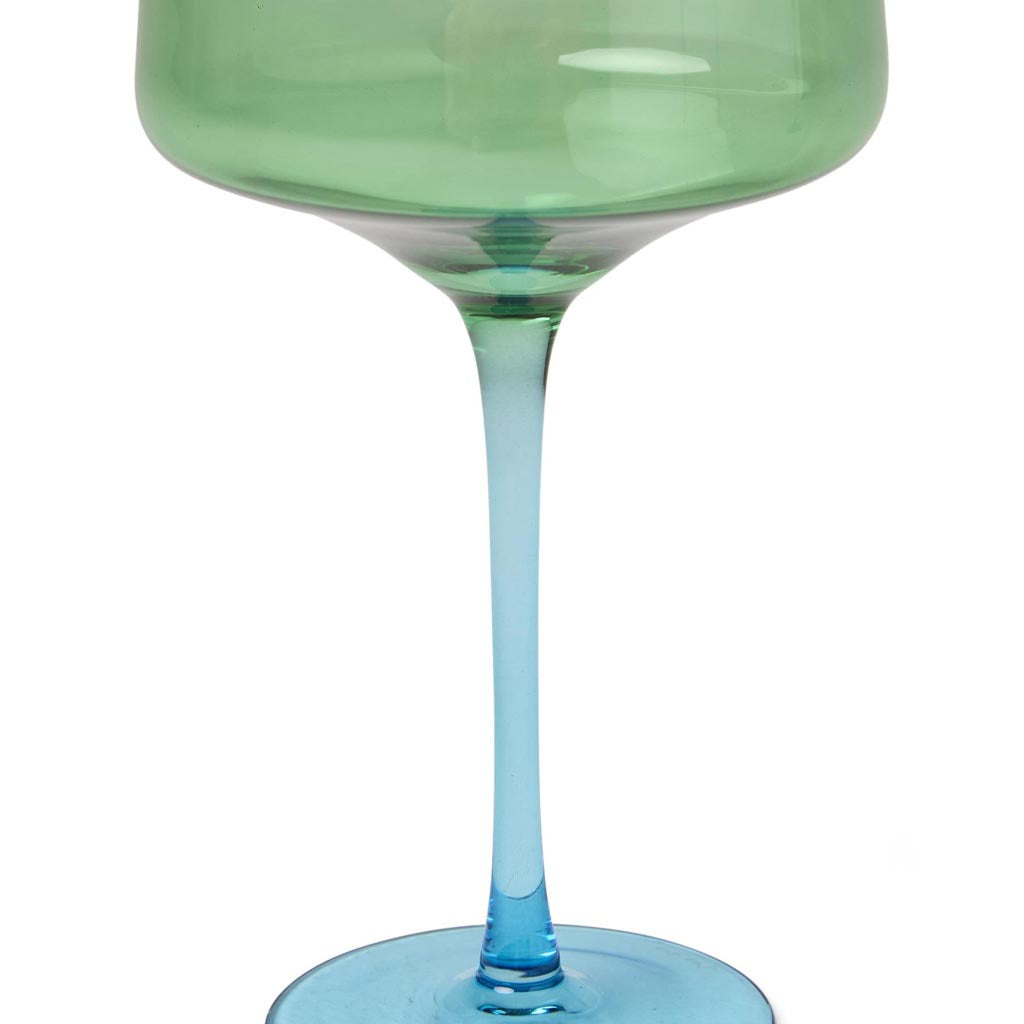 The image shows a set of two margarita glasses from Kip & Co, named "Pistachio Crush." The glasses are elegantly designed with a unique, textured surface that resembles crushed pistachios, giving them a distinctive and stylish appearance. The glassware is likely made of high-quality material, showcasing a blend of artistry and functionality, perfect for serving margaritas or other cocktails. The background is plain, ensuring the focus remains on the intricate details and vibrant color of the glasses.