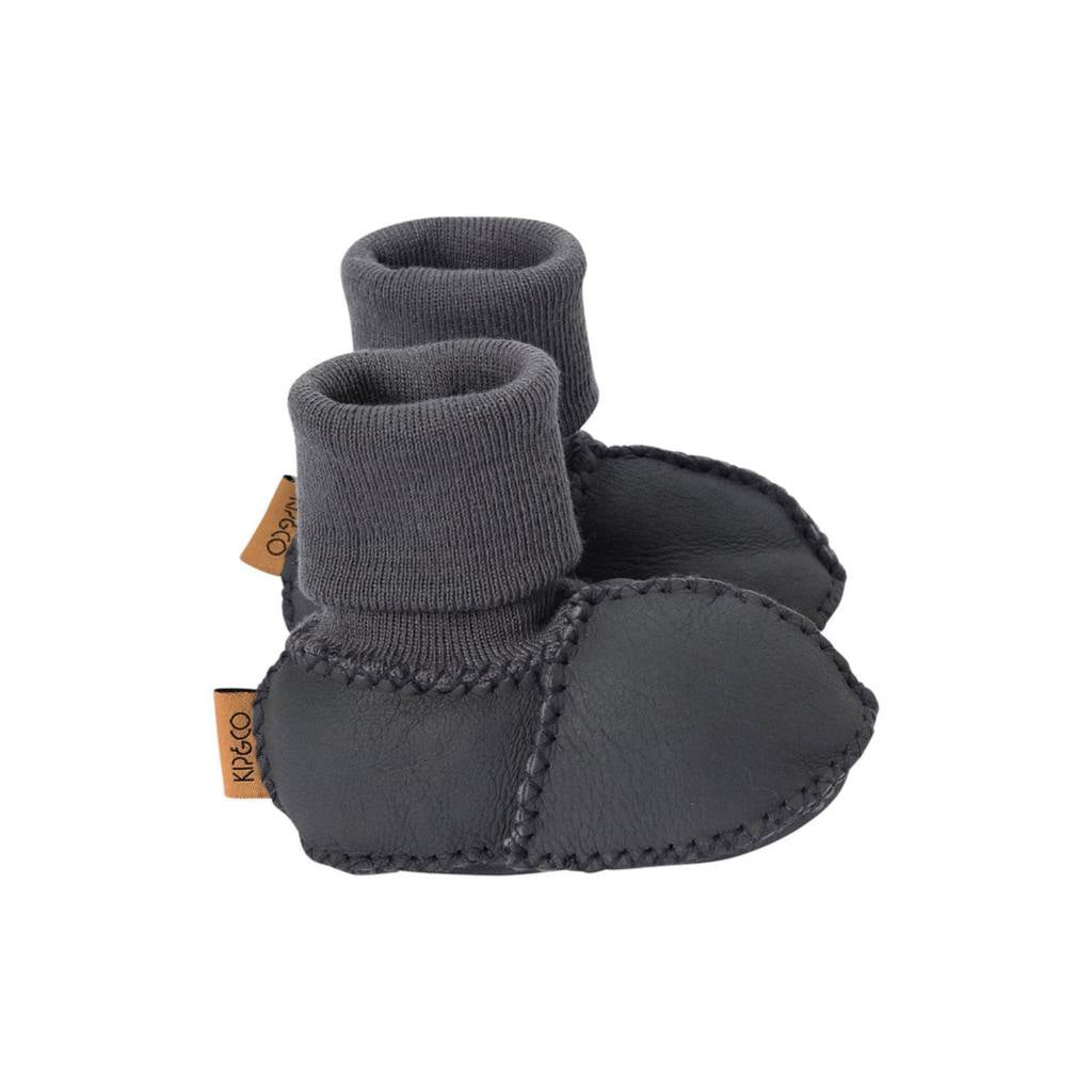 Pair of dark gray baby booties with a brand tag on a white background