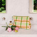 The image likely shows a stylish toiletry purse from Kip & Co in a pistachio tartan pattern, available at Cove Beach Essentials.