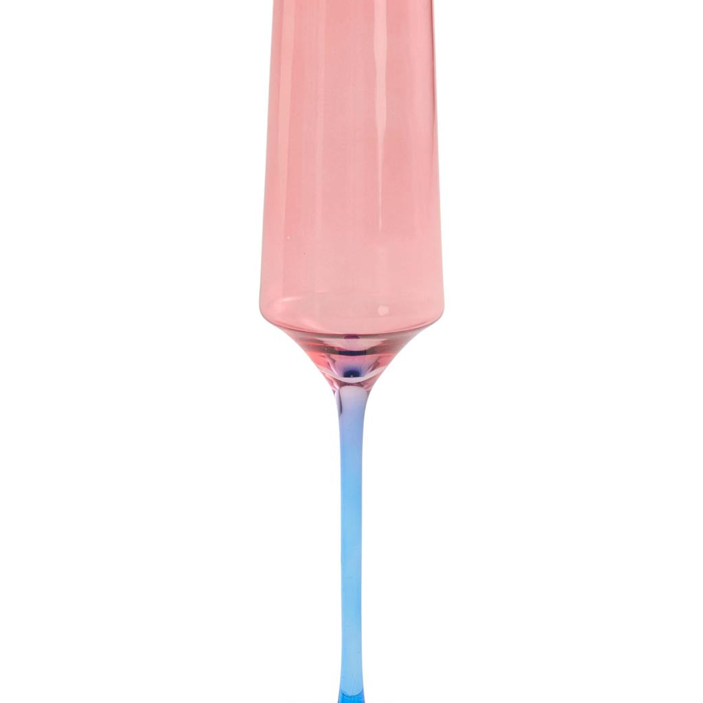 The image shows a set of two champagne glasses from Kip & Co. The glasses are elegantly designed with a blue robin motif, which adds a touch of whimsy and color to the otherwise clear glass. The glasses are positioned side by side, showcasing their tall, slender stems and wide, shallow bowls, typical of champagne glasses. The background is plain, ensuring that the focus remains on the intricate design and craftsmanship of the glassware.