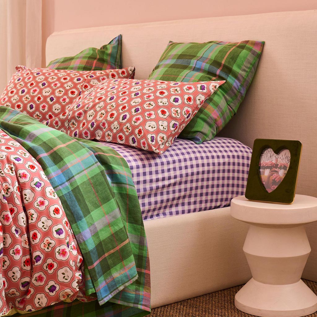 The image is a photo frame designed by Kip & Co, featuring a vibrant and colorful pattern. The frame is made of velvet material and is designed to hold a 6 x 8-inch photo. The pattern on the frame includes a variety of colors and shapes, creating a lively and eye-catching appearance. The frame is likely intended to add a touch of personality and style to any room where it is displayed.