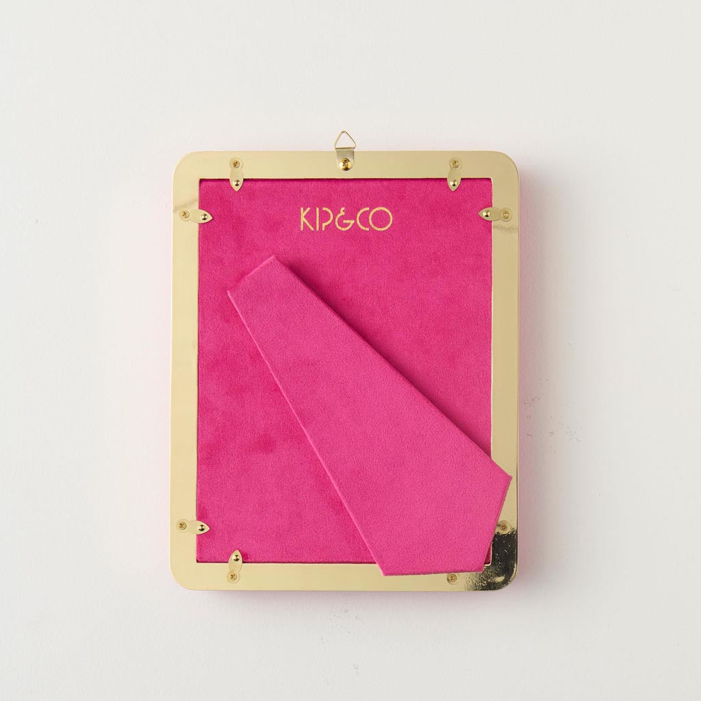 The image is of a photo frame designed by Kip & Co. It features a heart-shaped design and is made from a soft, plush velvet material in a desert pink color. The frame is intended to hold a 4 x 6 inch photograph. The velvet texture gives it a luxurious and cozy appearance, making it a stylish and decorative piece for displaying cherished memories.