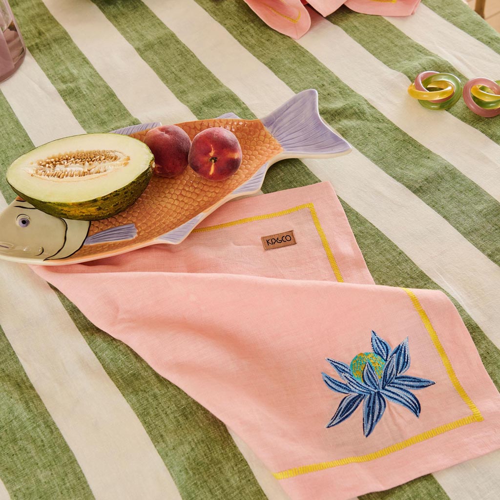 The image shows a decorative serving dish shaped like a fish. The dish is likely made of ceramic or a similar material and features a colorful, intricate design. The body of the fish is adorned with vibrant patterns and hues, possibly inspired by tropical or oceanic themes. The dish is designed to be both functional and aesthetically pleasing, suitable for serving food or as a decorative piece in a home setting.