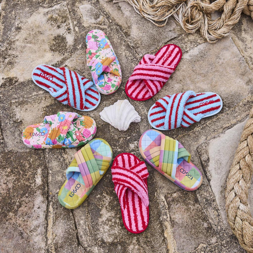 The image shows a pair of adult slippers made from quilted velvet material. The slippers are designed with a cozy and plush appearance, featuring a soft, textured surface that suggests comfort and warmth. The color of the slippers is a rich, warm tone, possibly a shade of yellow or gold, reminiscent of sunlight, which aligns with the "Follow The Sun" theme mentioned in the product name. The slippers have a simple, slip-on design, making them easy to wear. They are likely intended for indoor use, providing a