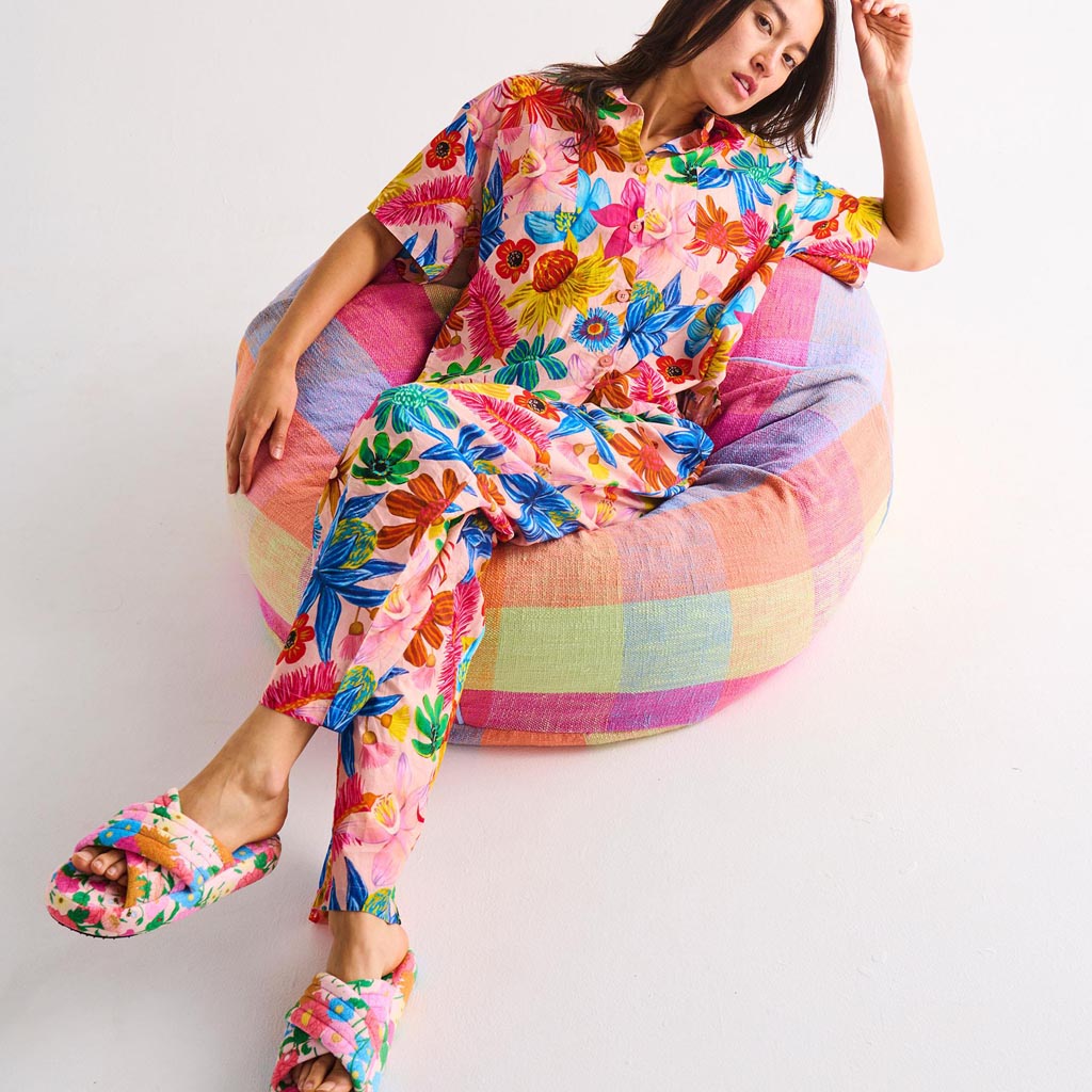 A pair of adult slippers made from quilted velvet material. The slippers have a soft, plush texture and are designed for comfort. They feature a warm, inviting color palette with a sun-inspired design, possibly incorporating shades of yellow, orange, or other warm tones. The slippers have a cozy, cushioned interior and a durable sole, suitable for indoor wear.