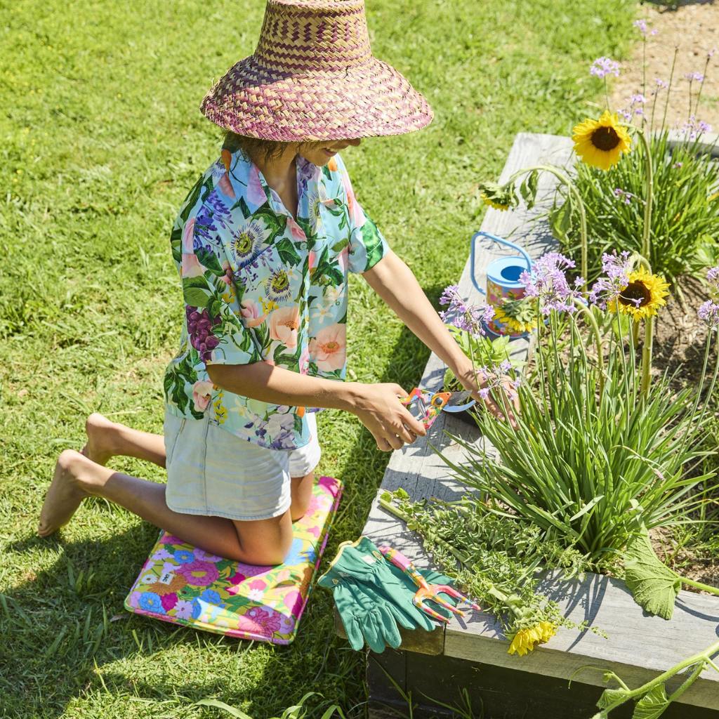 The image shows a gardening set consisting of a pair of yellow garden secateurs and matching gloves. The secateurs have a sleek design with a bright yellow handle, while the gloves are made from a durable material, also in a vibrant yellow color, with a textured grip on the palms and fingers for better handling. The set is displayed on a neutral background, highlighting the cheerful and sunny color theme.