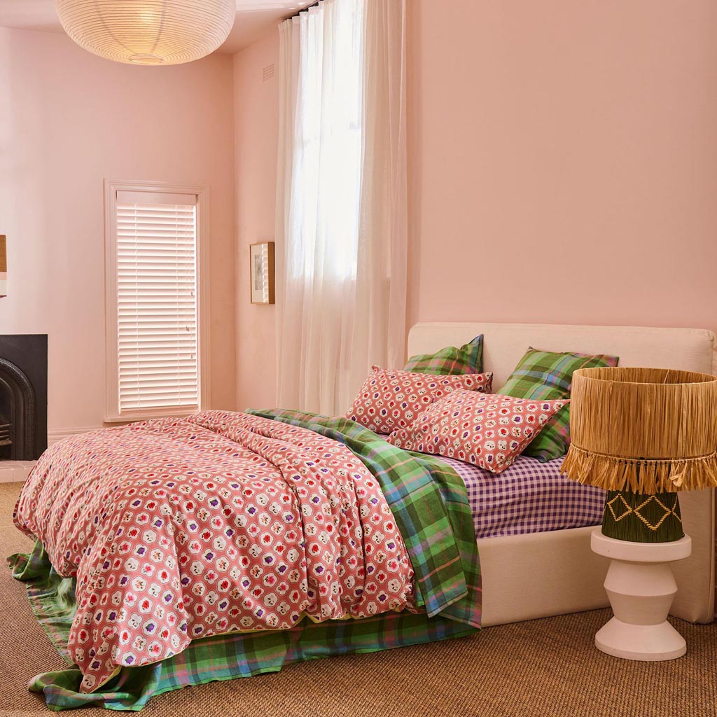 The image is of a stylish table lamp with a unique design. The lamp features a base made of natural raffia material, giving it a textured and earthy appearance. The lampshade is likely made of a light fabric, complementing the natural look of the base. The overall design of the lamp is modern yet rustic, making it a versatile piece that could fit into various interior decor styles. The lamp is likely part of a home decor collection, emphasizing a blend of natural materials and contemporary design.