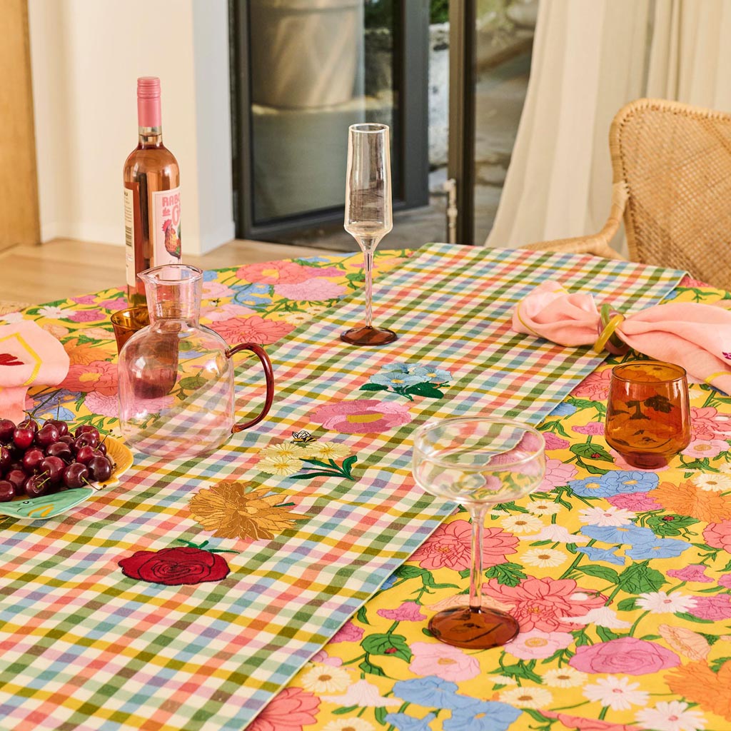 The image shows a set of two margarita glasses from Kip & Co. Each glass has a unique and colorful design, featuring a blend of pastel colors reminiscent of marshmallows and marmalade. The glasses have a classic margarita shape with a wide, shallow bowl and a long stem. The vibrant colors and artistic patterns give the glasses a playful and stylish appearance, making them suitable for festive occasions or as a decorative piece.