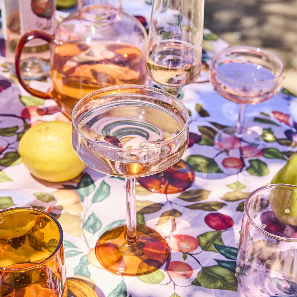 The image shows a set of two margarita glasses from Kip & Co. Each glass features a unique and colorful design, with one glass predominantly showcasing a marshmallow-like pattern and the other a marmalade-inspired design. The glasses are likely made of glass and have a wide, shallow bowl typical of margarita glasses, with a short stem and a sturdy base. The vibrant colors and artistic patterns give the set a playful and stylish appearance, suitable for serving cocktails in a fun and festive setting.