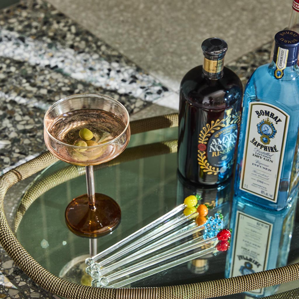 The image shows a set of two margarita glasses from Kip & Co. Each glass features a unique and colorful design, with a combination of pastel and vibrant hues resembling marshmallows and marmalade. The glasses have a classic margarita shape with a wide, shallow bowl and a long stem, making them both stylish and functional for serving cocktails. The background is likely a neutral color to highlight the intricate patterns and colors of the glasses.