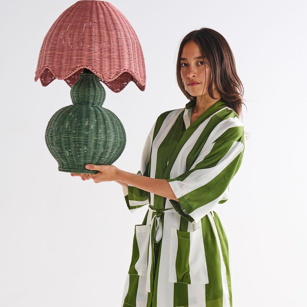 The image is of a robe made from eco-friendly satin material. The robe features a design with horizontal stripes in various shades of green, resembling moss. It has a relaxed fit with long sleeves and a belt for tying around the waist. The fabric appears smooth and shiny, highlighting the luxurious texture of satin. The robe is displayed against a plain background, emphasizing its pattern and color.