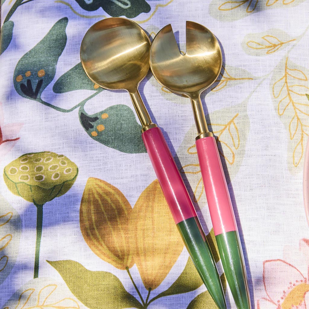 The image shows a set of salad servers, which typically includes a fork and a spoon designed for serving salads. These particular servers have a unique and artistic design, featuring a colorful and vibrant pattern reminiscent of Tuscan or Mediterranean styles. The handles are likely made of a durable material, possibly wood or metal, and are adorned with intricate, multicolored designs that add a decorative touch. The serving ends are functional and polished, suitable for tossing and serving salads. The ove
