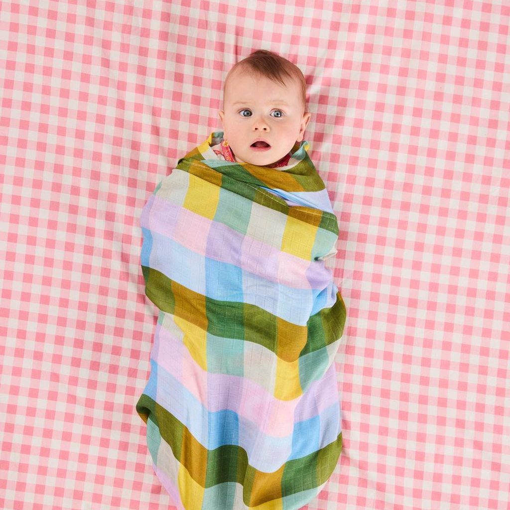 Baby wrapped in the Sorbet Tartan bamboo swaddle