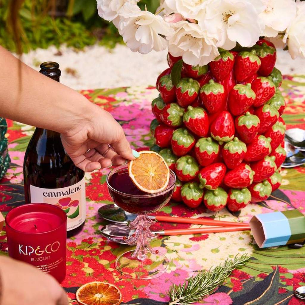 Strawberry Jam vase on a table with drinks and citrus
