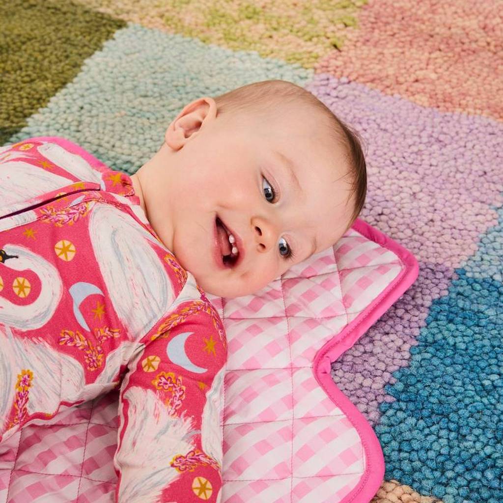 Close-up of baby smiling on the Swanette change mat