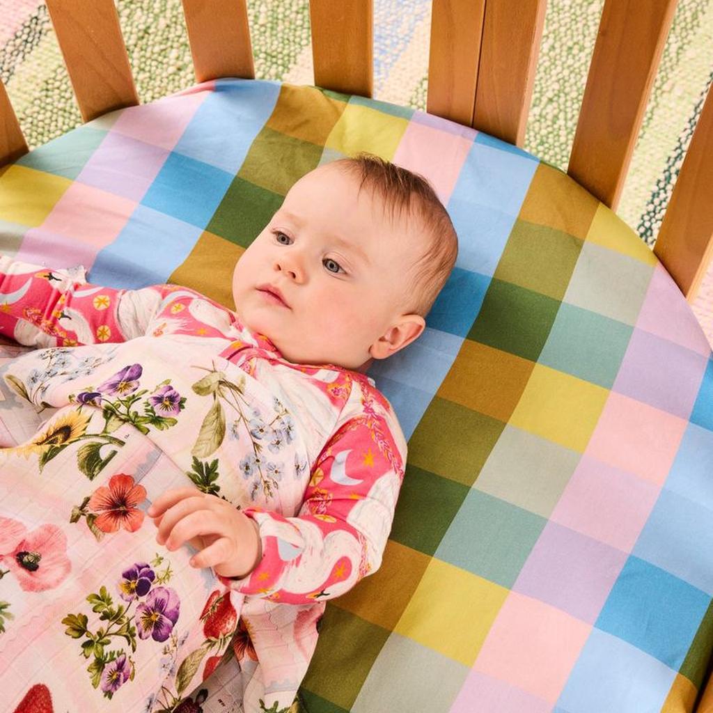 Baby in a cot with the Sweet Life swaddle