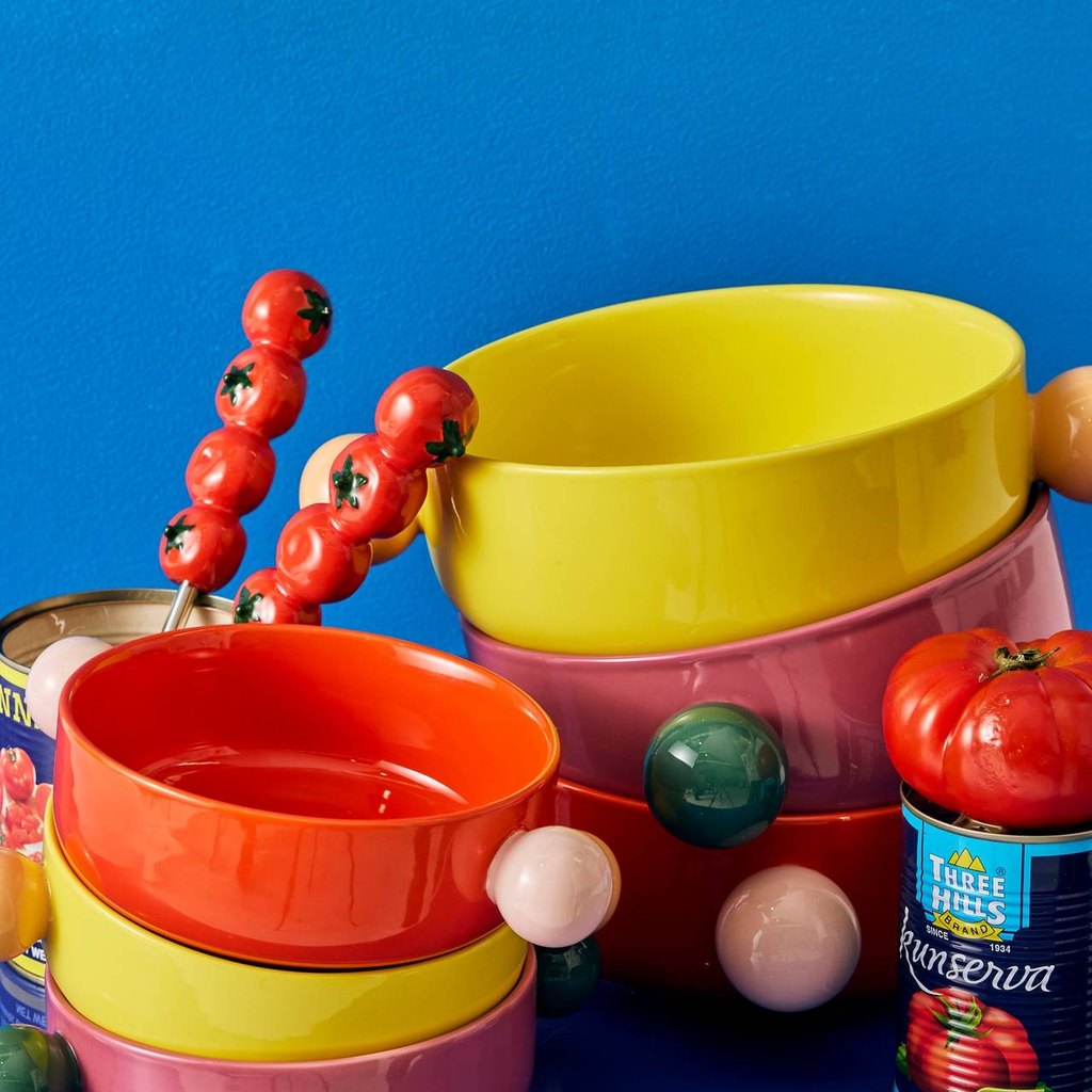 Tomato salad servers in a stack of colourful bowls