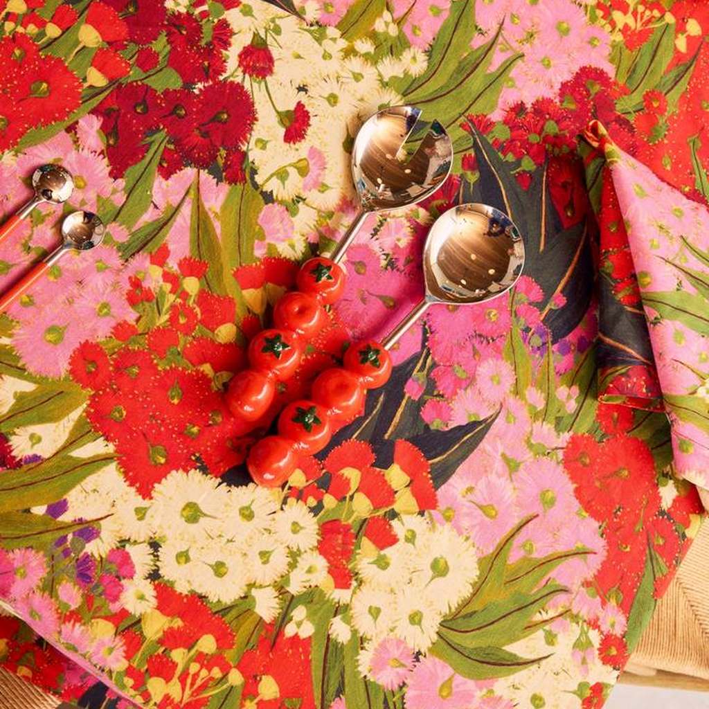 Tomato salad servers on a red floral tablecloth