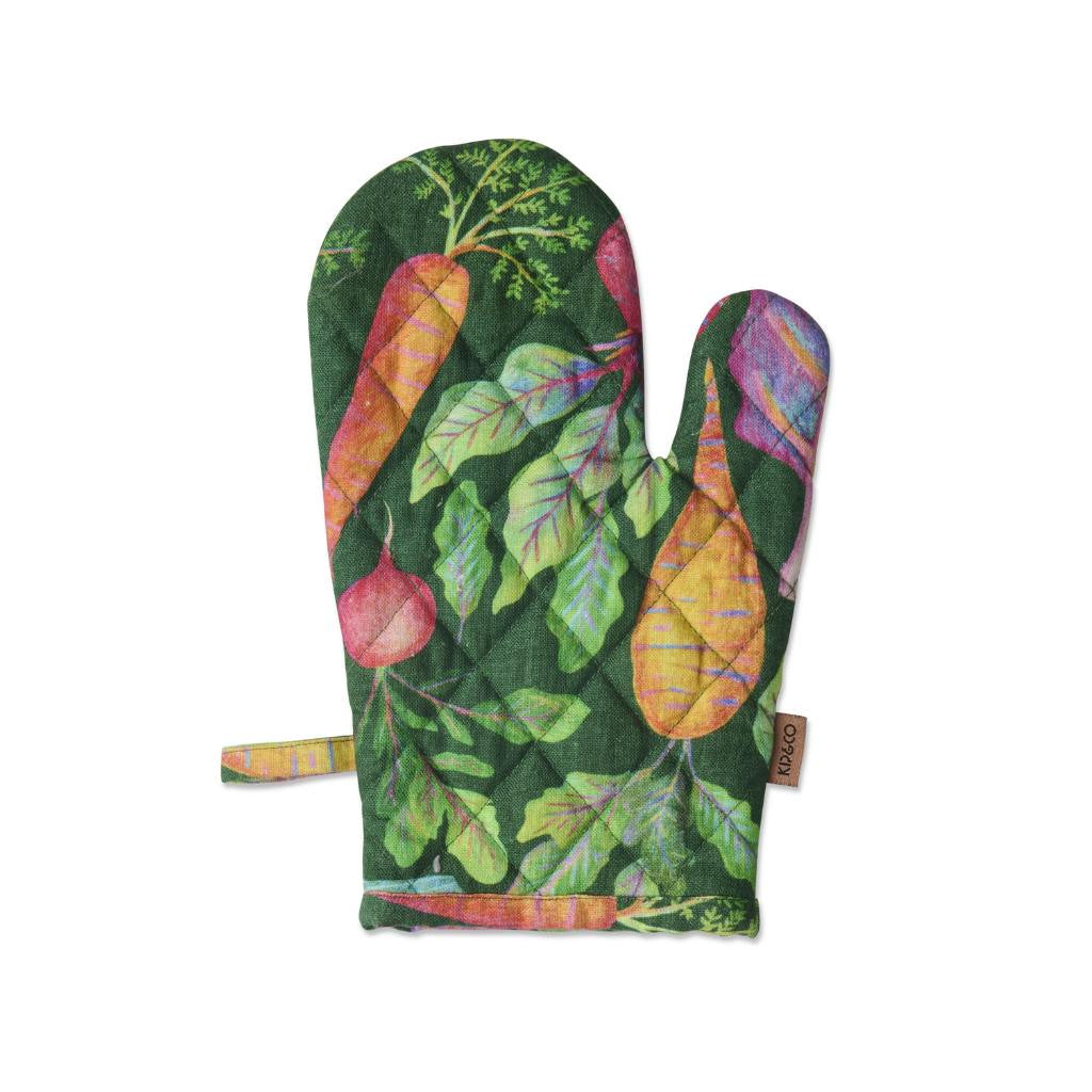 The image shows a colorful kitchen set consisting of an oven mitt and a tea towel. Both items are adorned with a vibrant vegetable soup theme, featuring illustrations of various vegetables like carrots, tomatoes, and greens, along with soup bowls and spoons. The design is playful and bright, adding a cheerful touch to any kitchen decor. The background is likely a neutral color to make the colorful illustrations stand out.