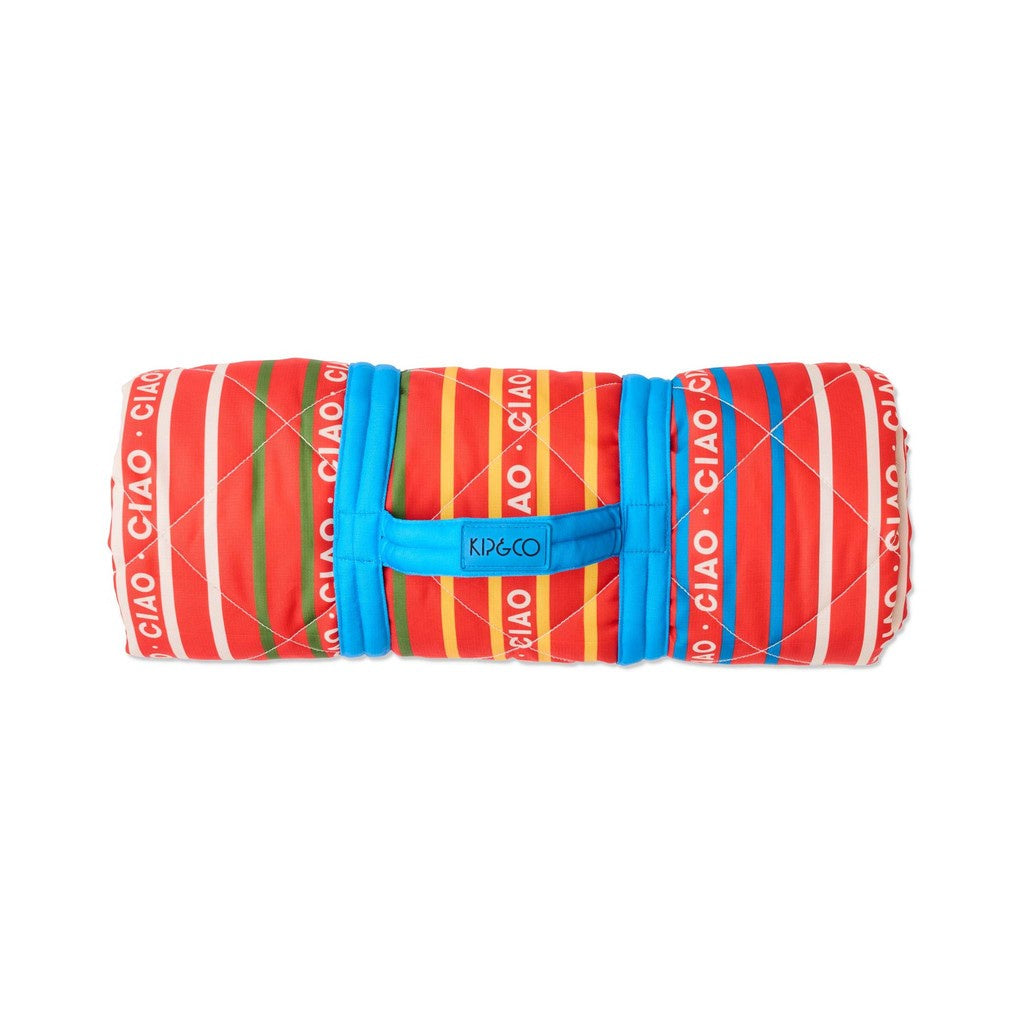 Kip & Co Ciao Stripe picnic mat rolled up with a blue carry strap