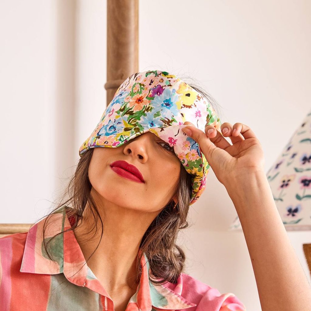 Woman adjusting the Alfresco block out silk eye mask