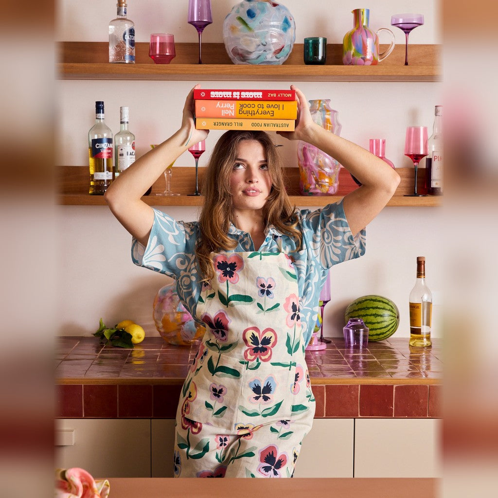 Woman wearing the Kip & Co Pretty Pansy Apron at the bench