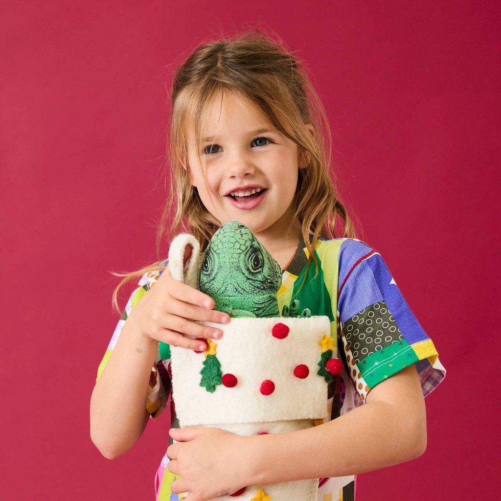 Smiling girl holding the Under The Tree felt stocking